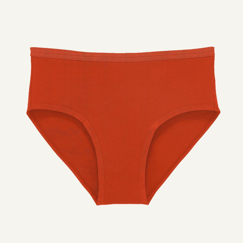 A pair of solid rust-orange briefs shown flat against a light off-white background.