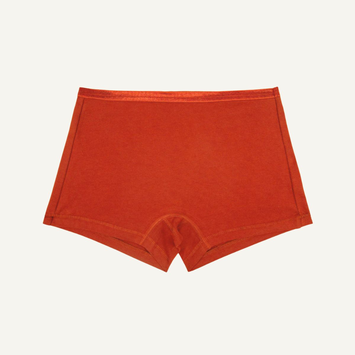A pair of women's briefs in a solid burnt orange color, laid flat against a light off-white background.