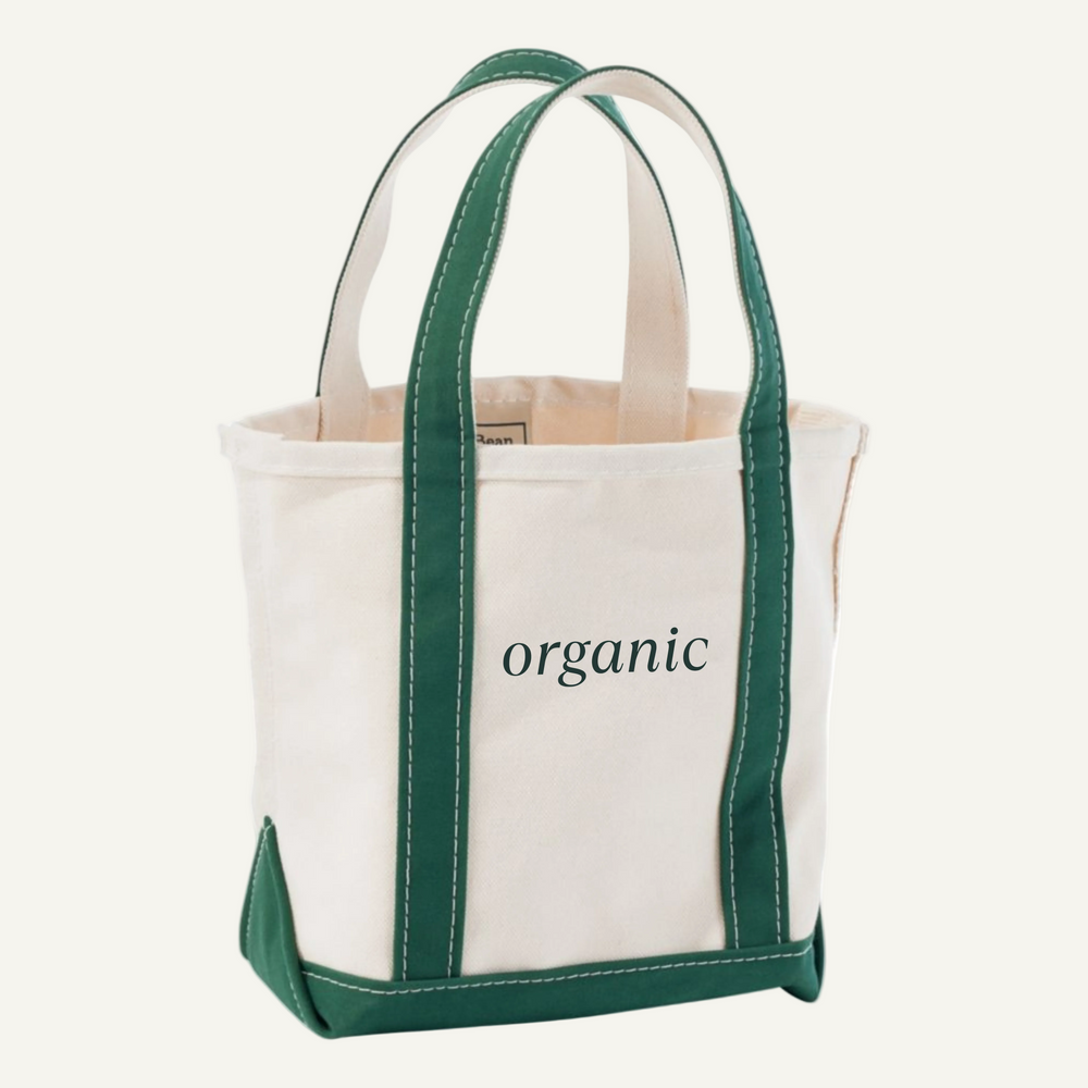 Tote bag with green handles and trim, featuring the word 'organic' on a light beige background.